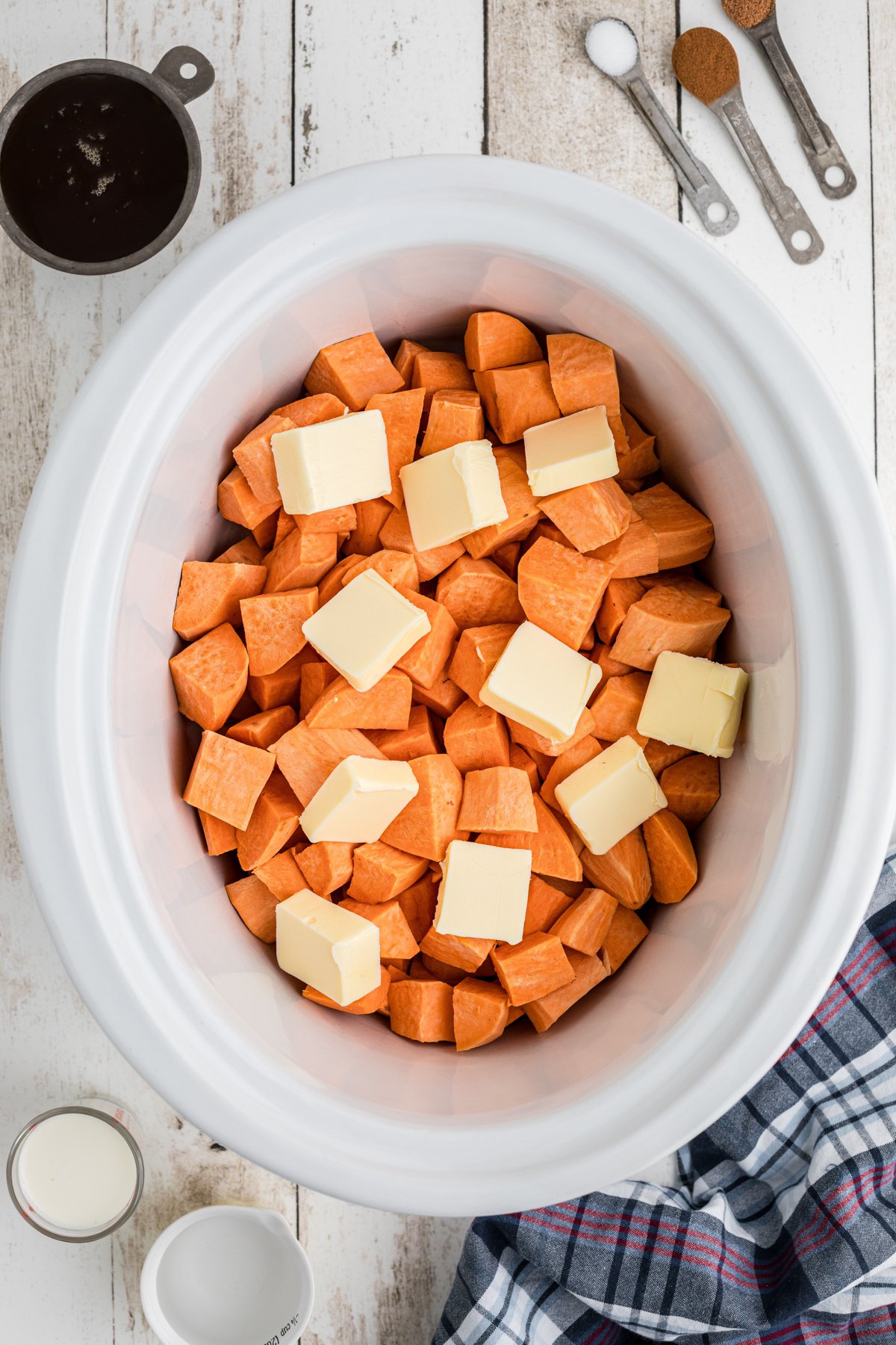 sweet potatoes and butter pats in a slow cooker.