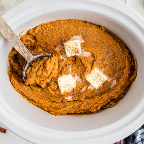 cooked and mashed sweet potatoes with butter pats.