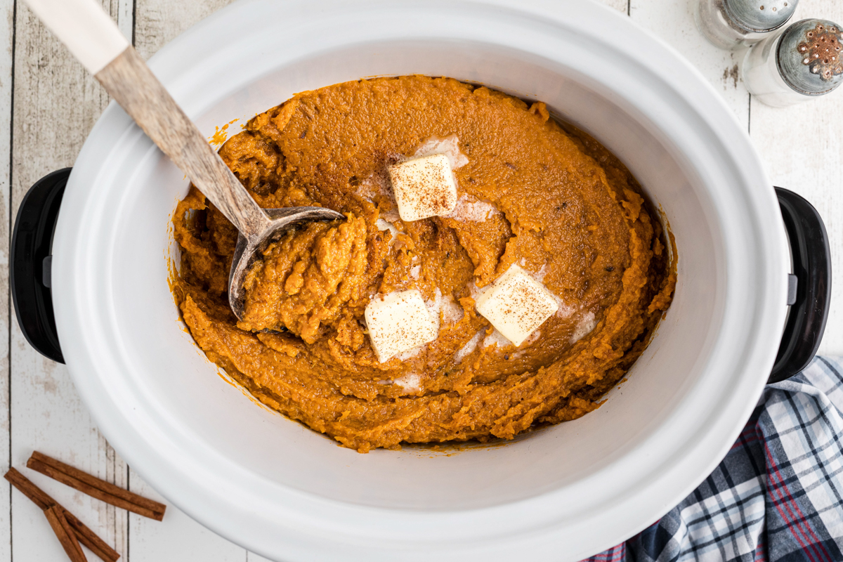 cooked and mashed sweet potatoes with butter pats.