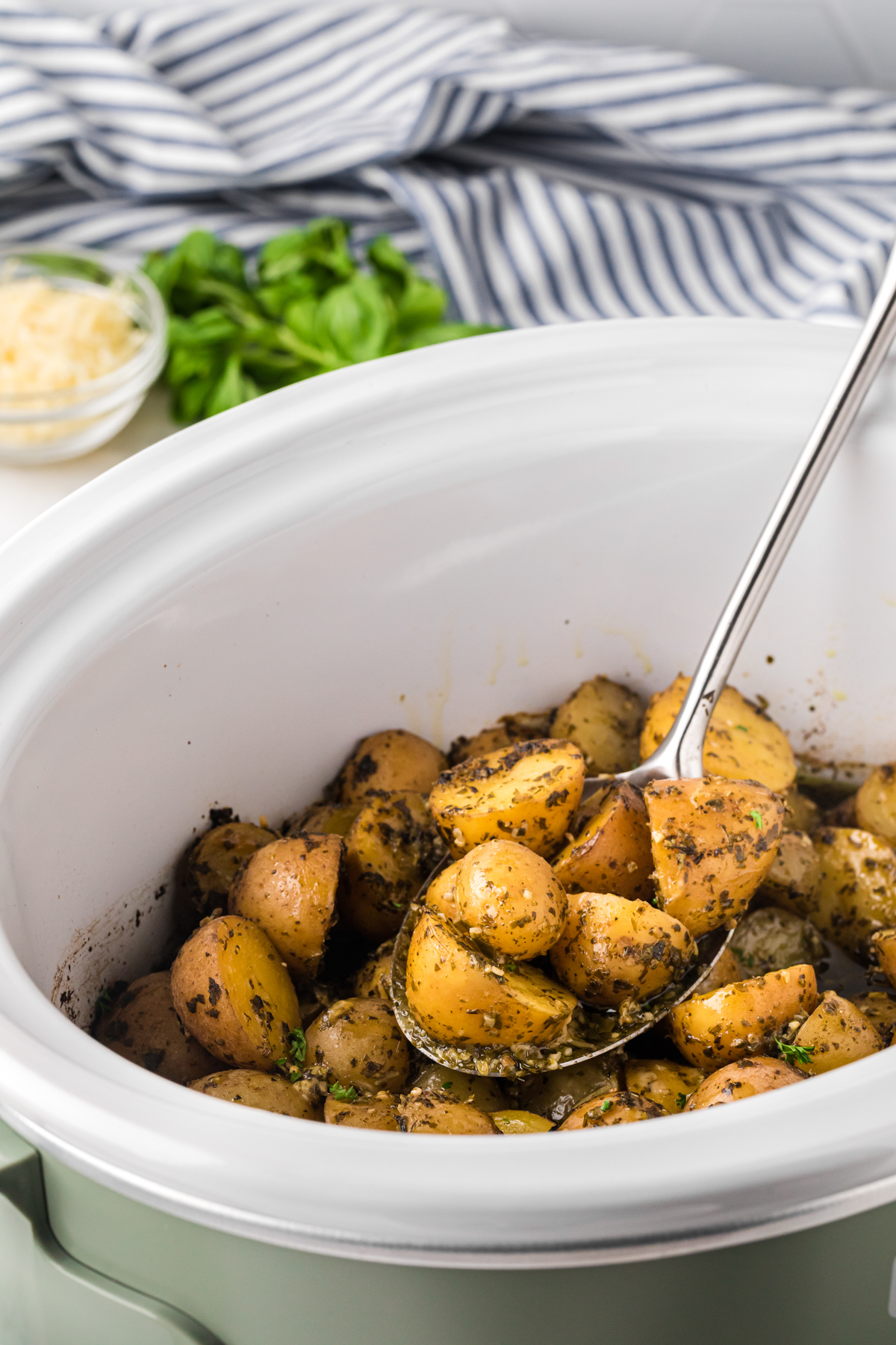Cooked pesto parmesan potatoes in with spoon in it.