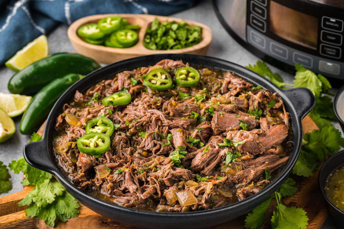 salsa verde beef in a round black serving dish.