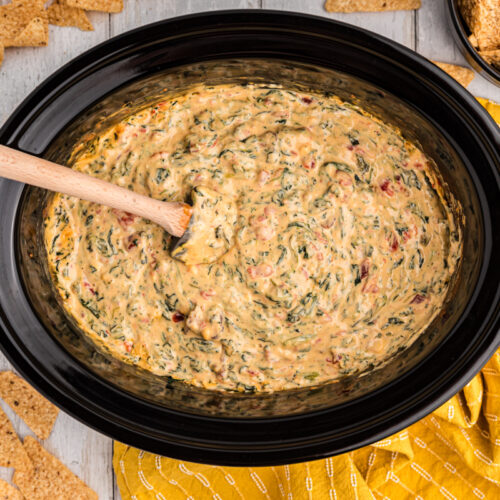 Overhead shot of velveeta spinach with chips on a side.