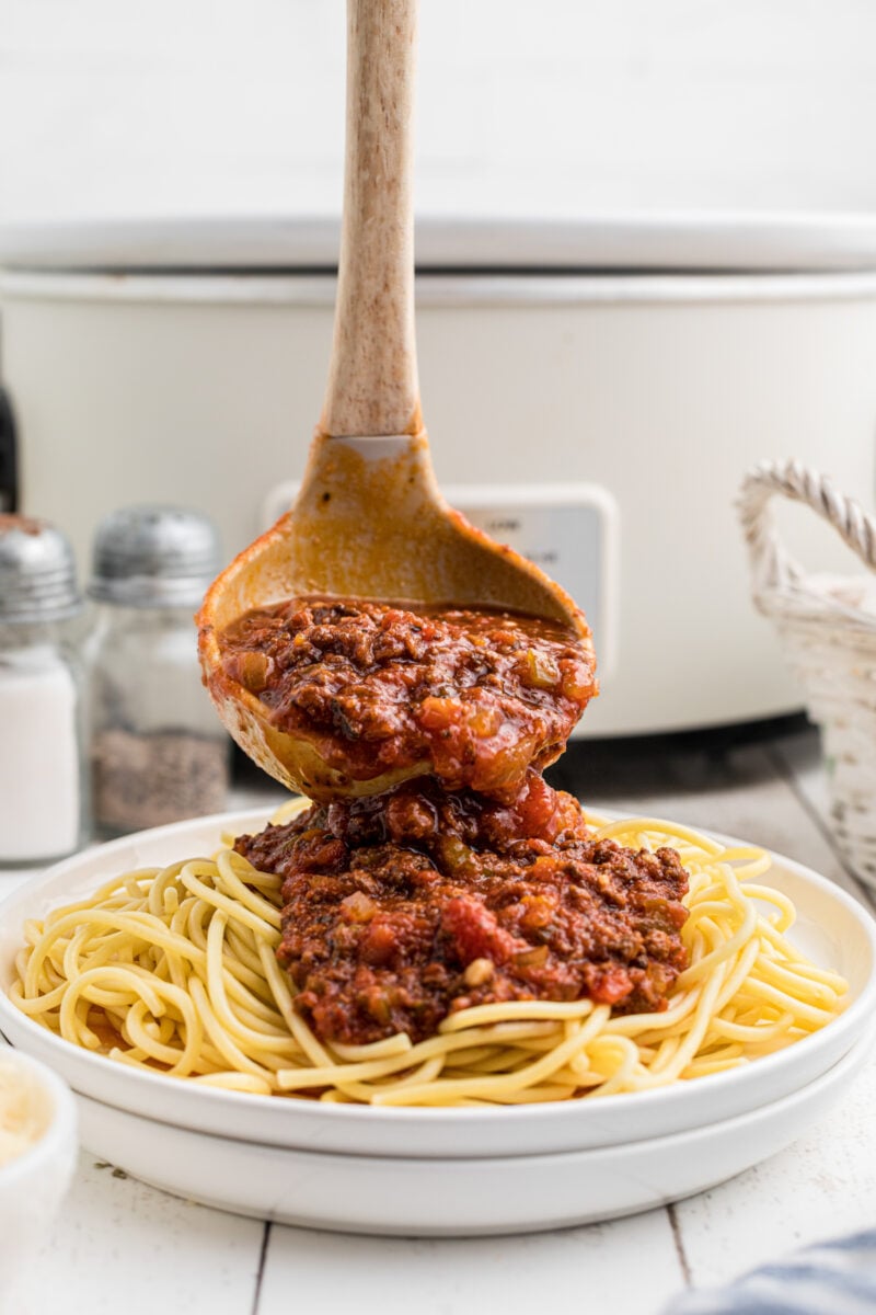 Venison Spaghetti sauce being poured over noodles.