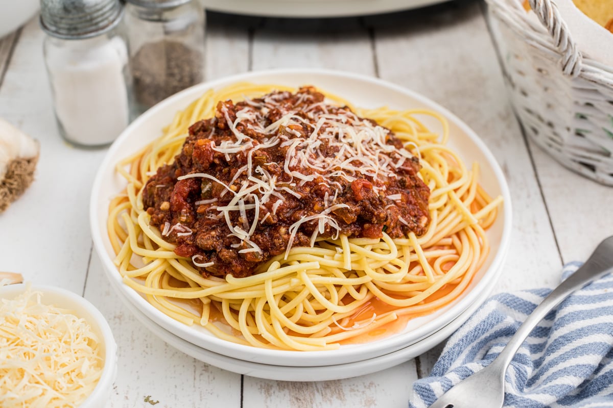 Spaghetti sauce and noodles with parmesan cheese on top.