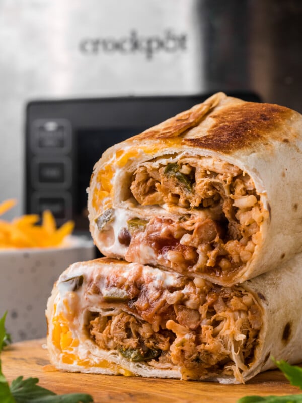 Burrito cut in half on a cutting board.
