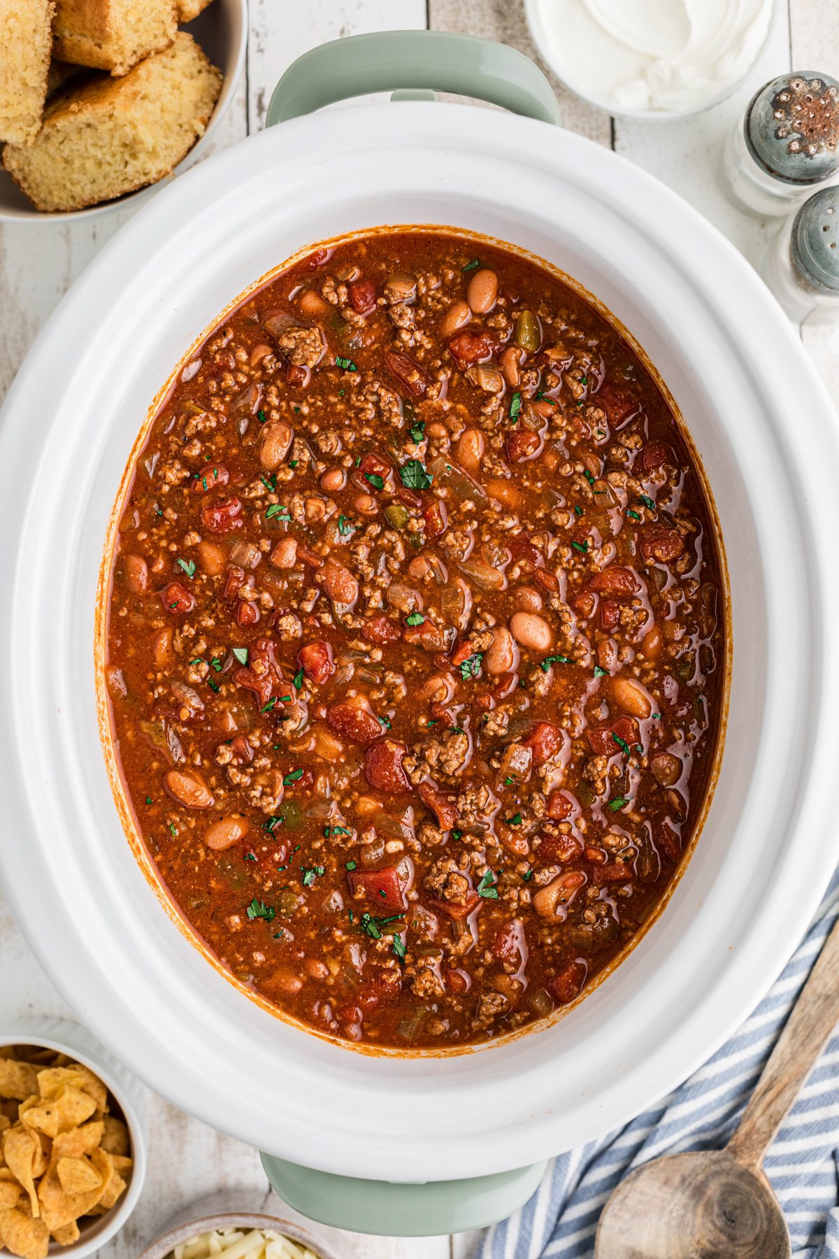 Crockpot full of chili with cornbread on the side.