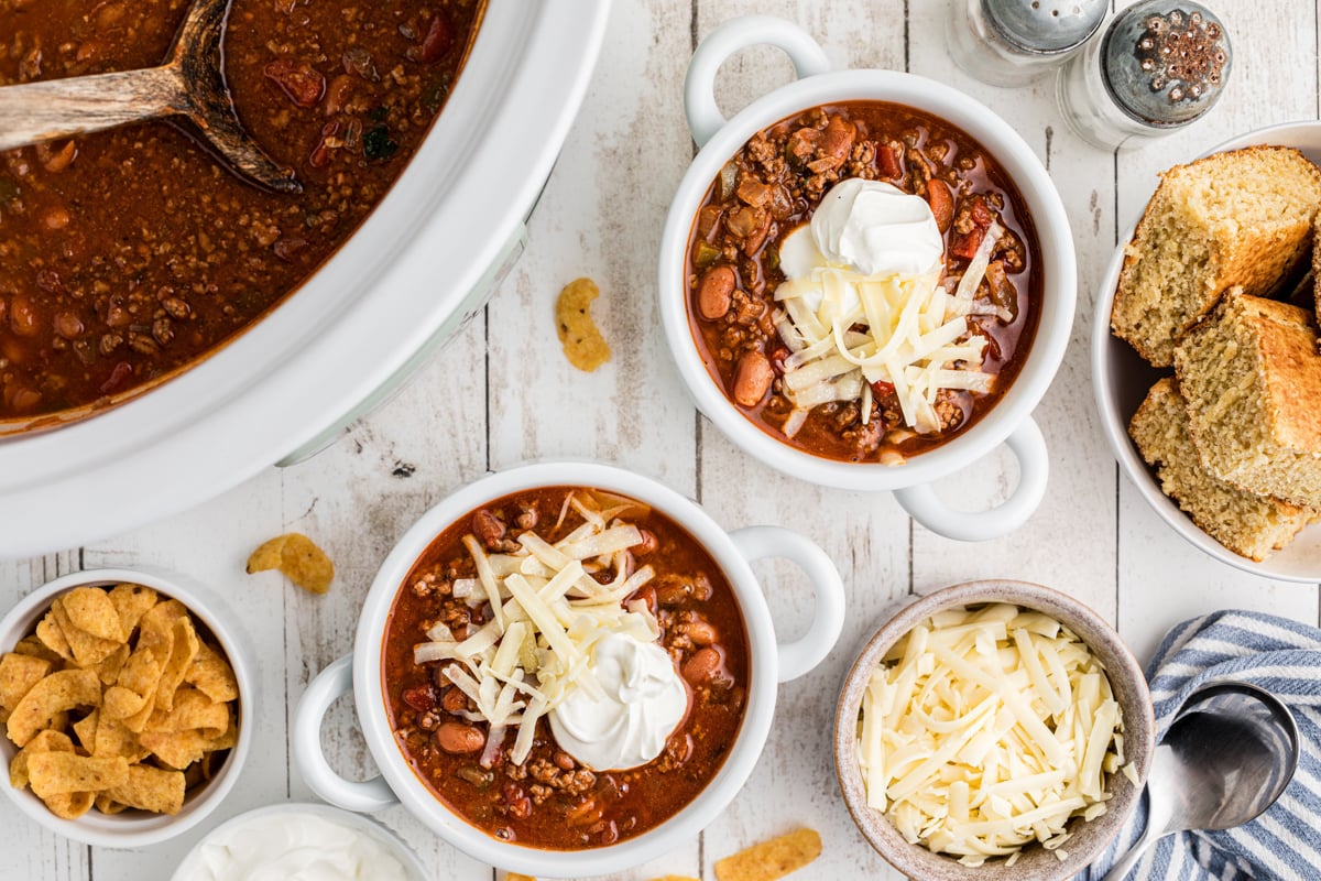 2 bowls of crockpot chili with sour cream and cheese.