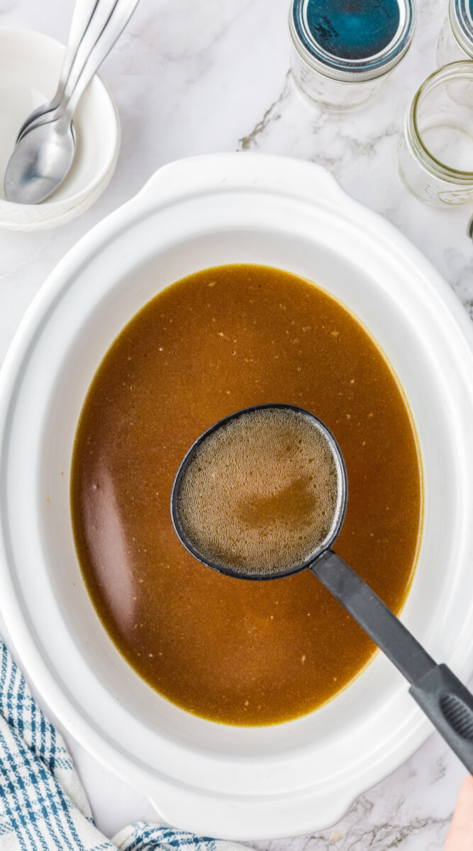 Long image of chicken stock in a slow cooker.