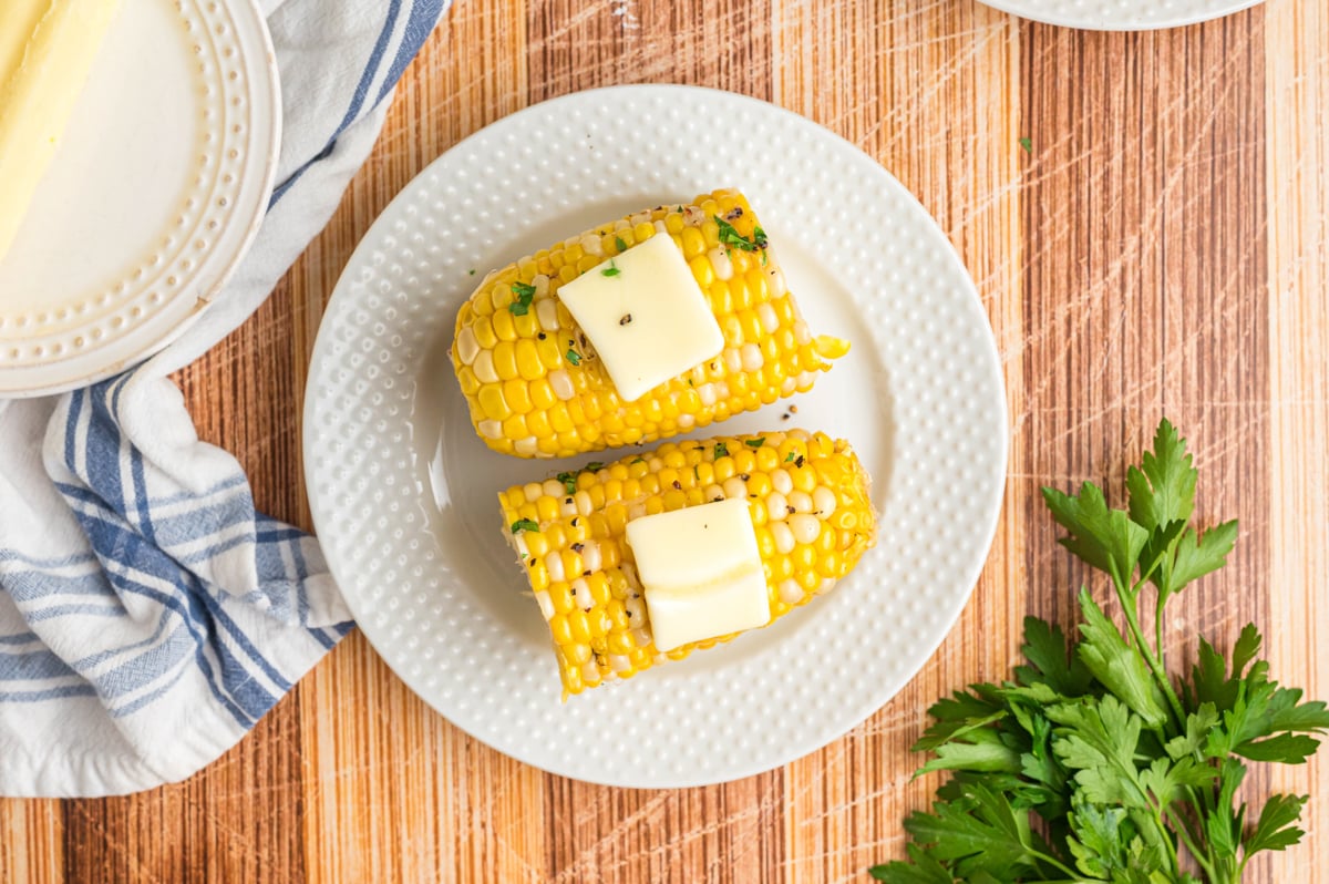 overhead shot of 2 pieces of corn with butter.