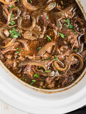 overhead of french onion pot roast in a slow cooker.