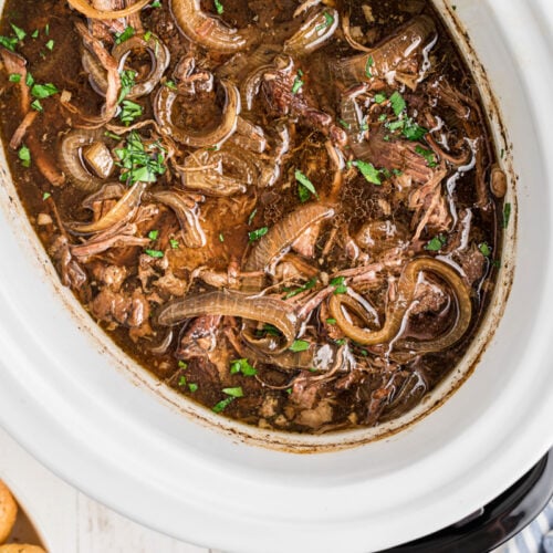overhead of french onion pot roast in a slow cooker.