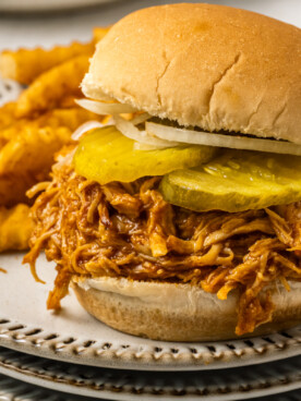 Spicy chicken sandwich on a plate wit fries.