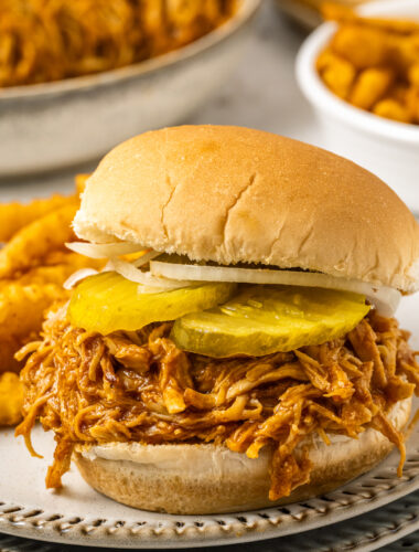 A spicy chicken sandwich on a plate with fries.