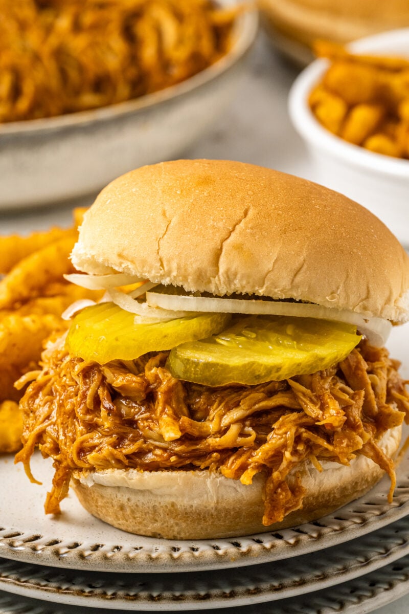 A spicy chicken sandwich on a plate with fries.