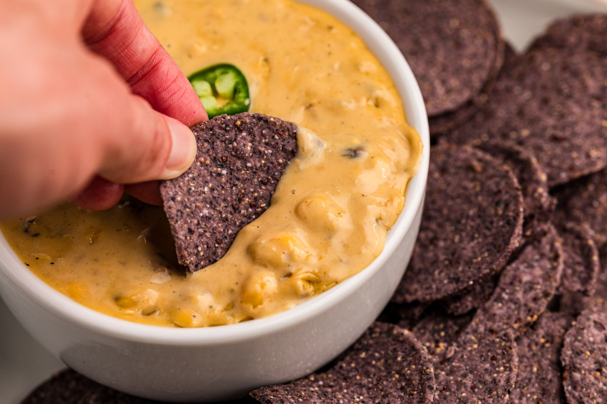 chip being dipped into a queso dip.