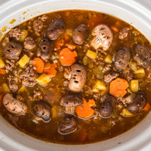Cooked witches brew stew in a white slow cooker.