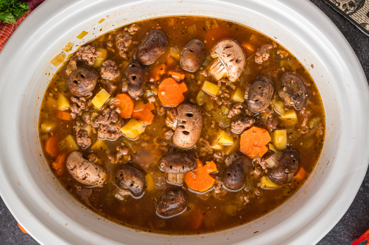 Cooked witches brew stew in a white slow cooker.