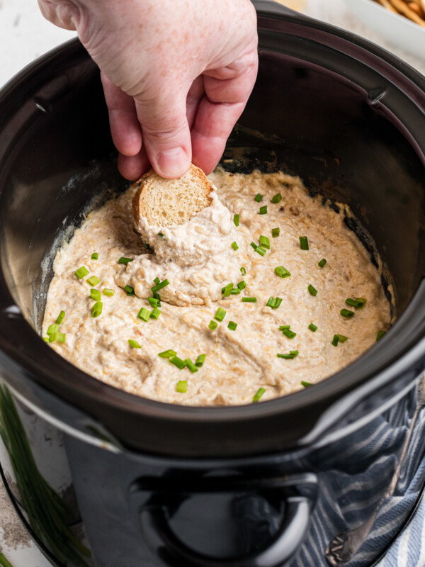 Bread being dipped into french onion dip.