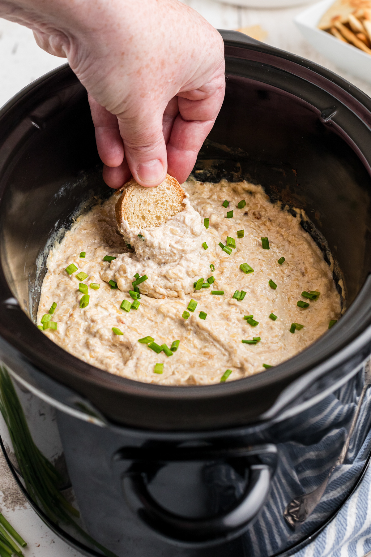 Bread being dipped into french onion dip.