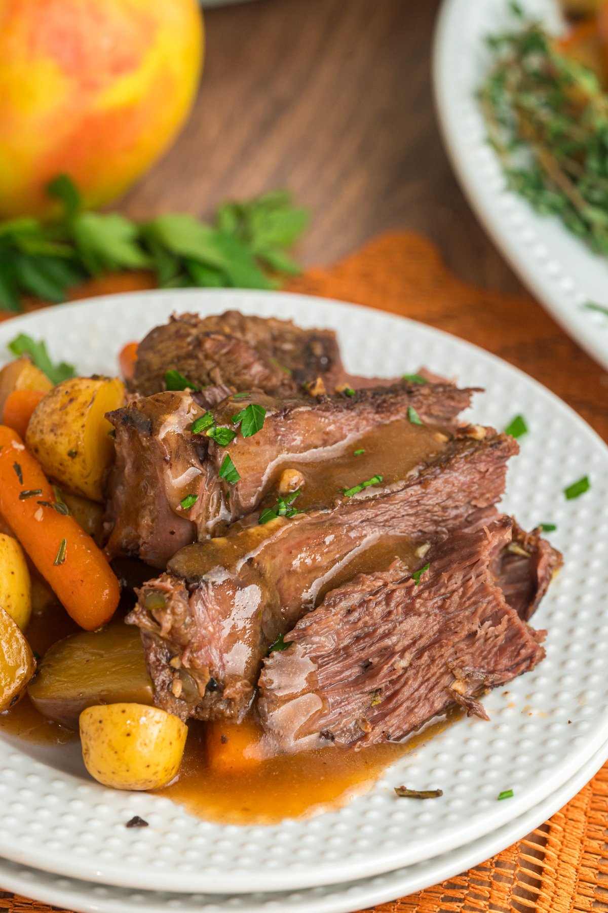 Apple cider pot roast with carrots and potatoes on a plate.