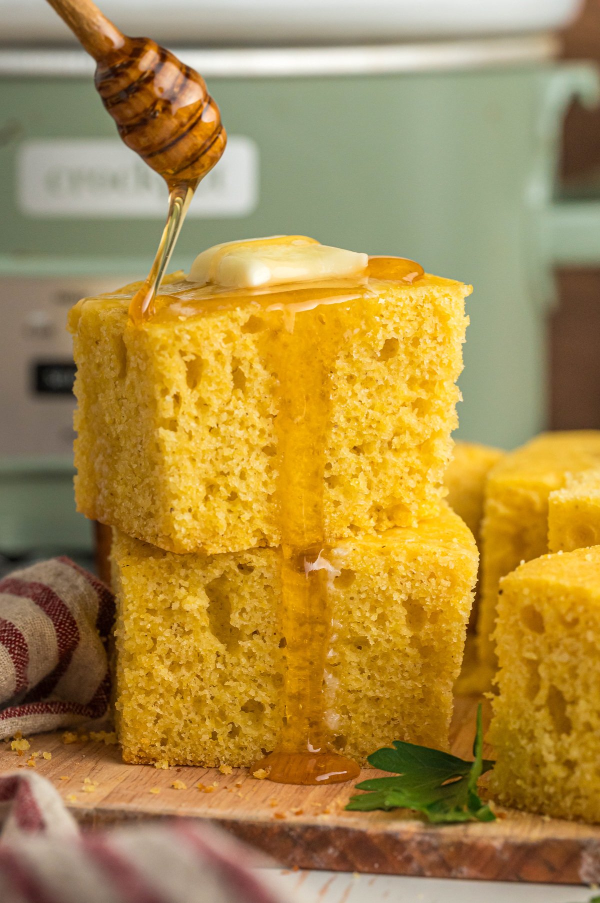 2 pieces of cornbread with honey being drizzled over.
