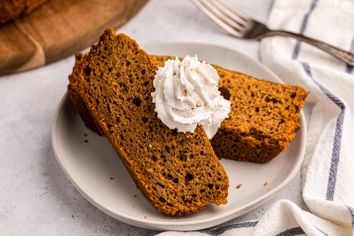 2 slices of pumpkin bread with a dollop of whipped cream.