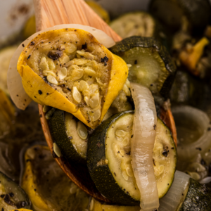 Close up of zucchini and squash with onion in a slow cooker.