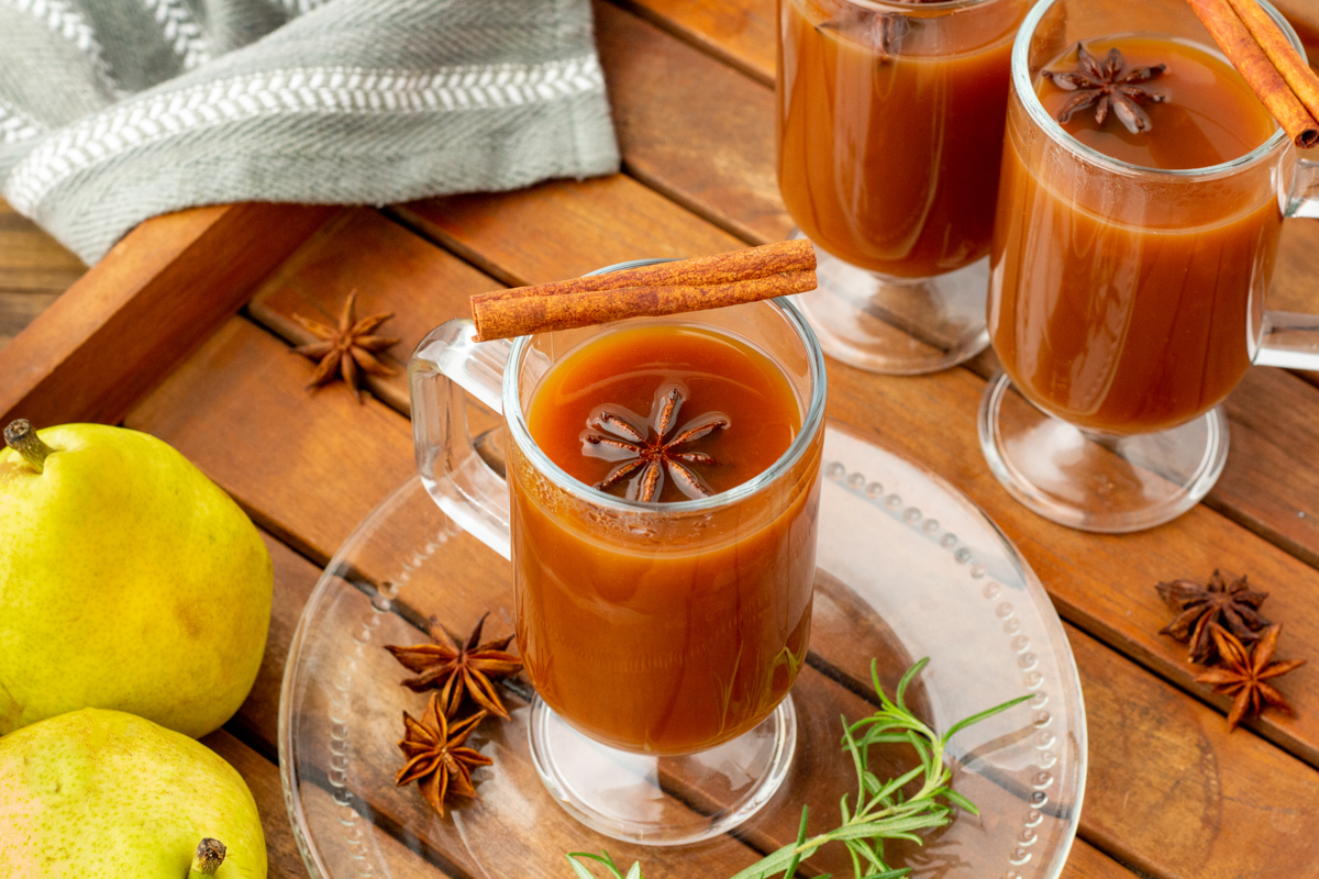 pear cider in a mug with a cinnamon stick on top.