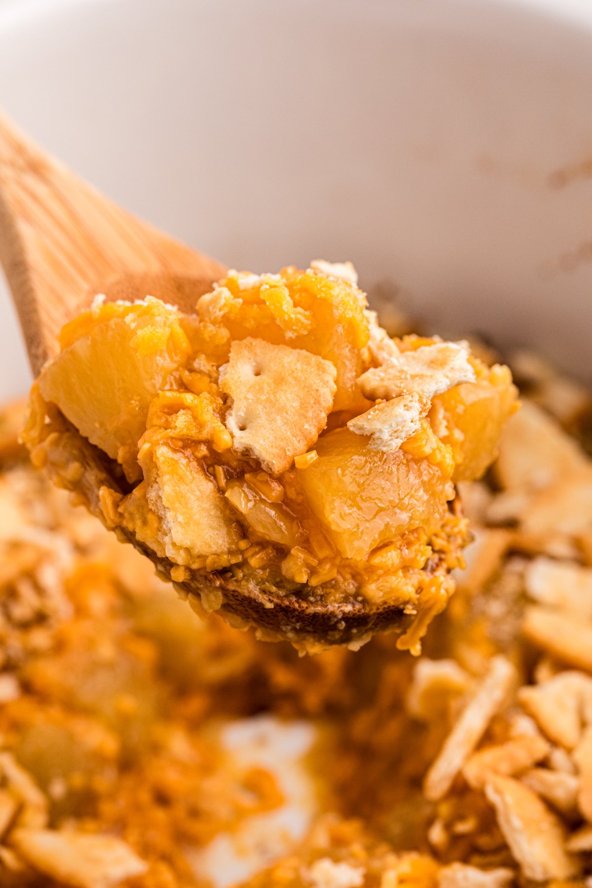 close up of pineapple casseroel on a spoon.