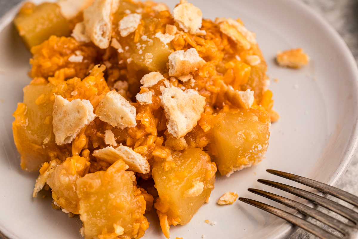 Plate of pineapple casserole with ritz crackers on top.