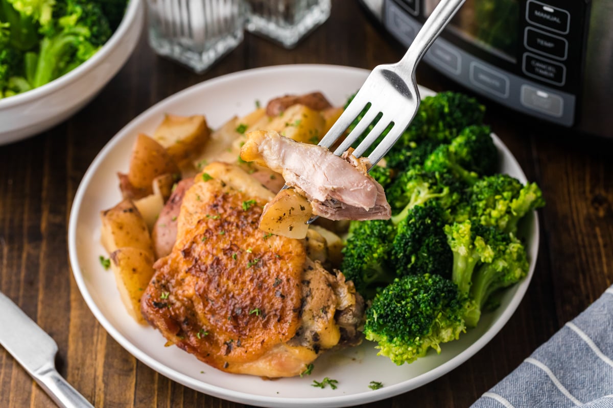 plate with a chicken thigh, red potatoes and broccoli.