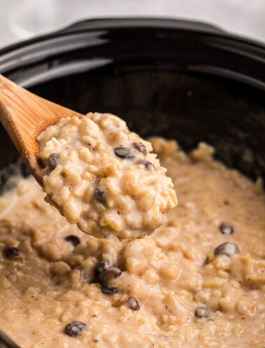 Rice pudding on a spoon coming from a crockpot.