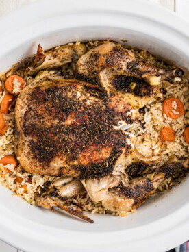 Overhead shot of chicken and rice in a slow cooker.