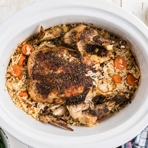 Overhead shot of chicken and rice in a slow cooker.