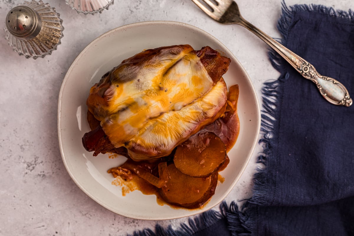 overhead of slow cooker barbecue pork chops and potatoes on a white plate.