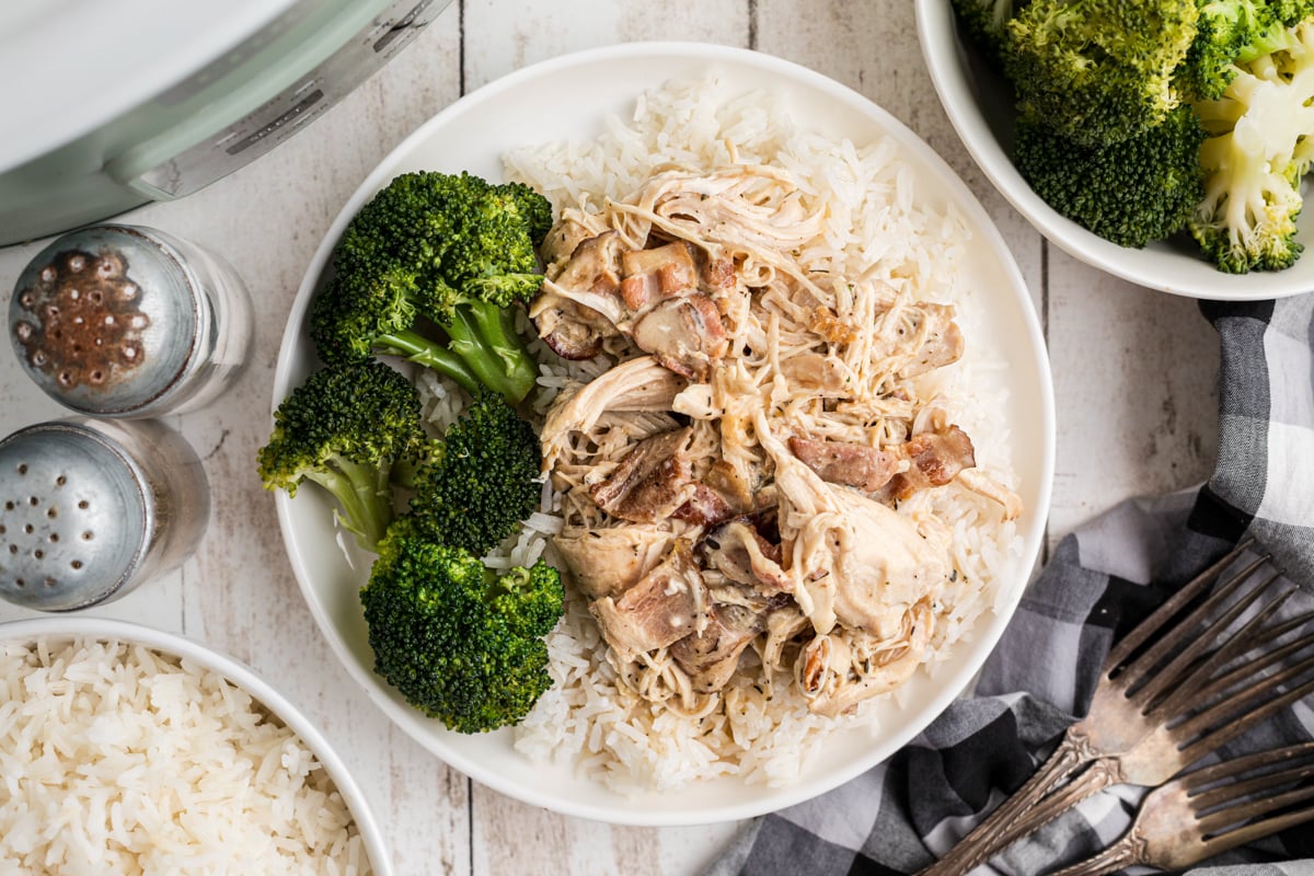 Chicken, gravy, rice and broccoli on a plate.