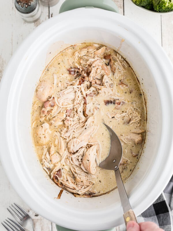 chicken with gravy with bacon with spoon in it.