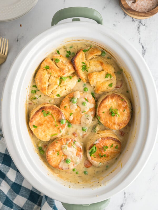 overhead of chicken pot pie with biscuits in a white crockpot.
