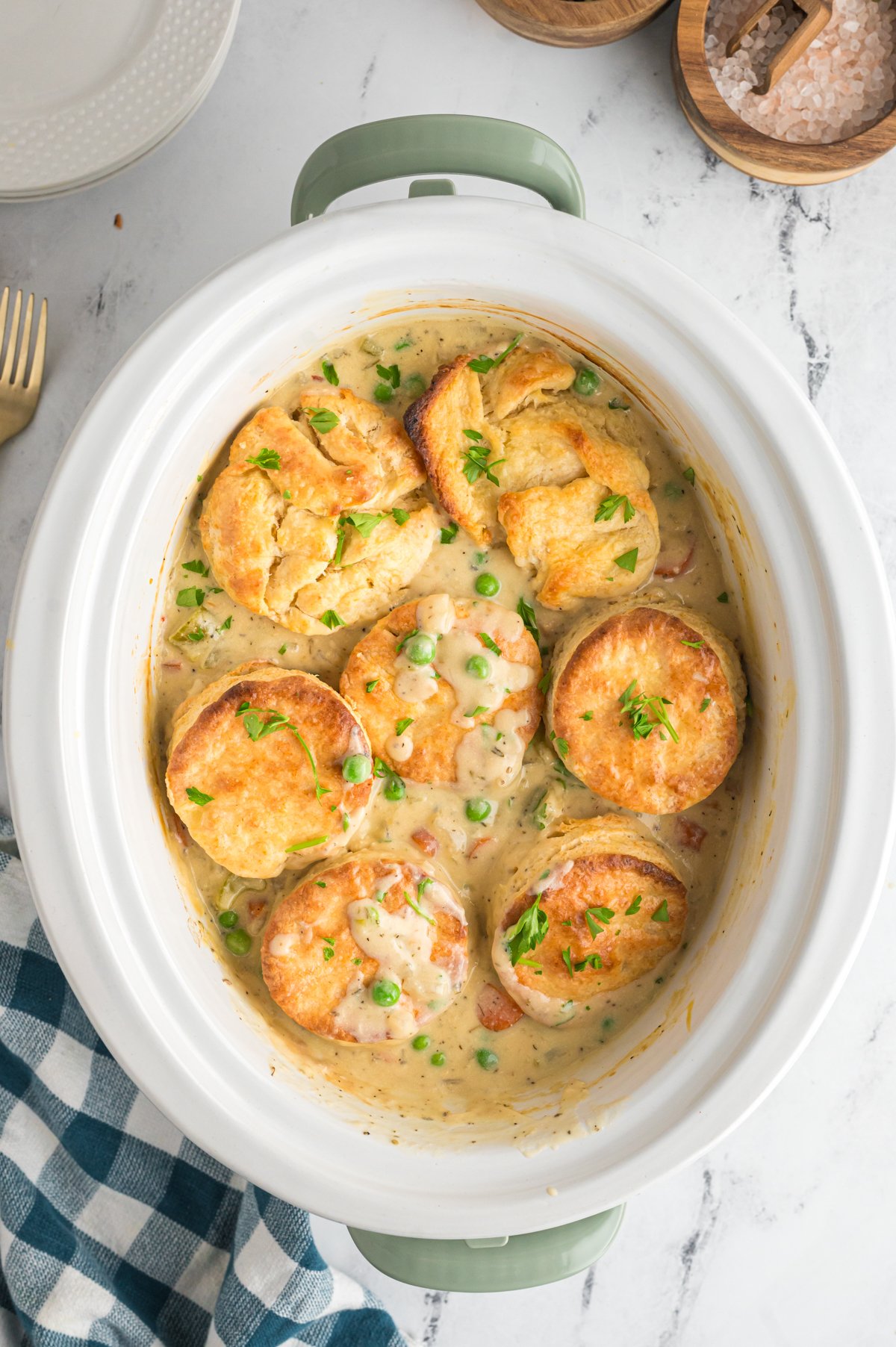 overhead of chicken pot pie with biscuits in a white crockpot.