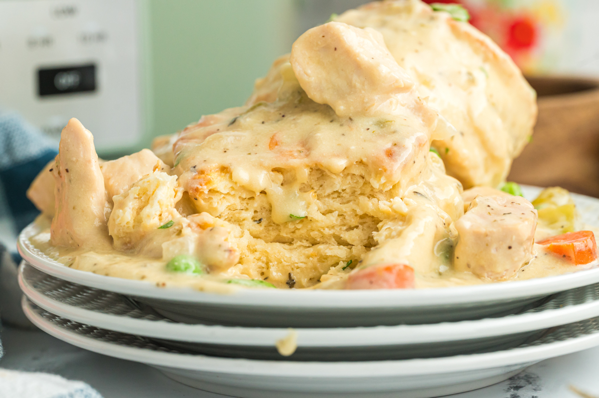 Serving of slow cooker chicken pot pie with one of the biscuits showing the inside.