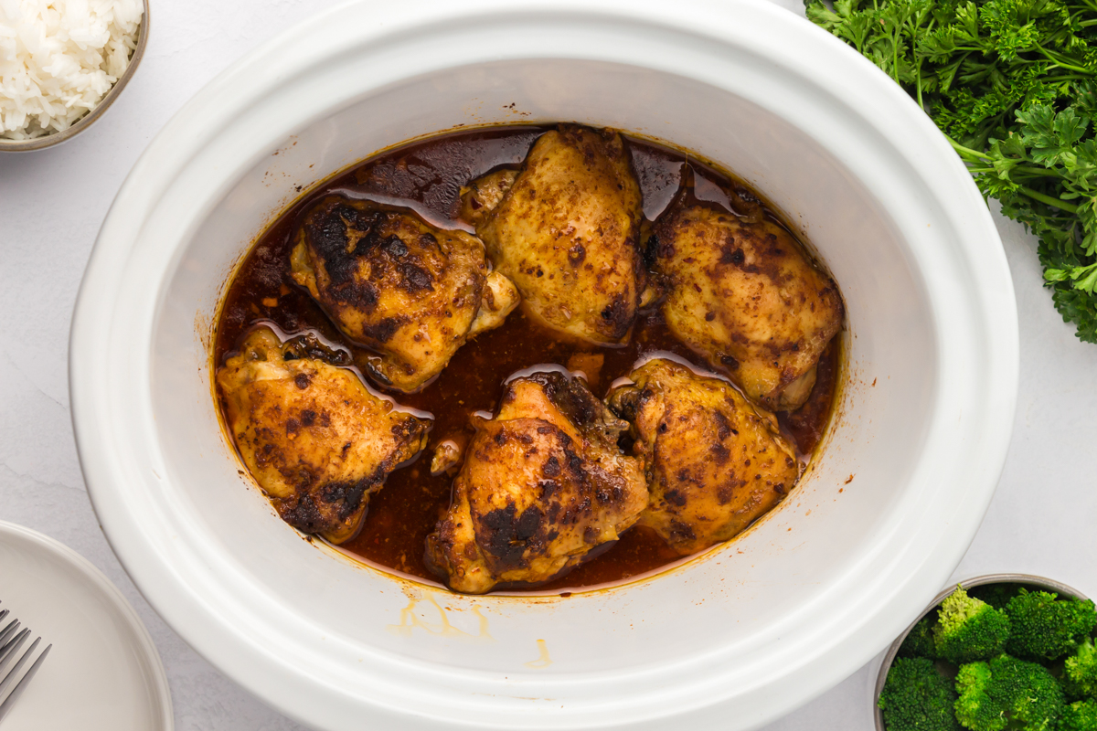 overhead of chicken thighs in a slow cooker.