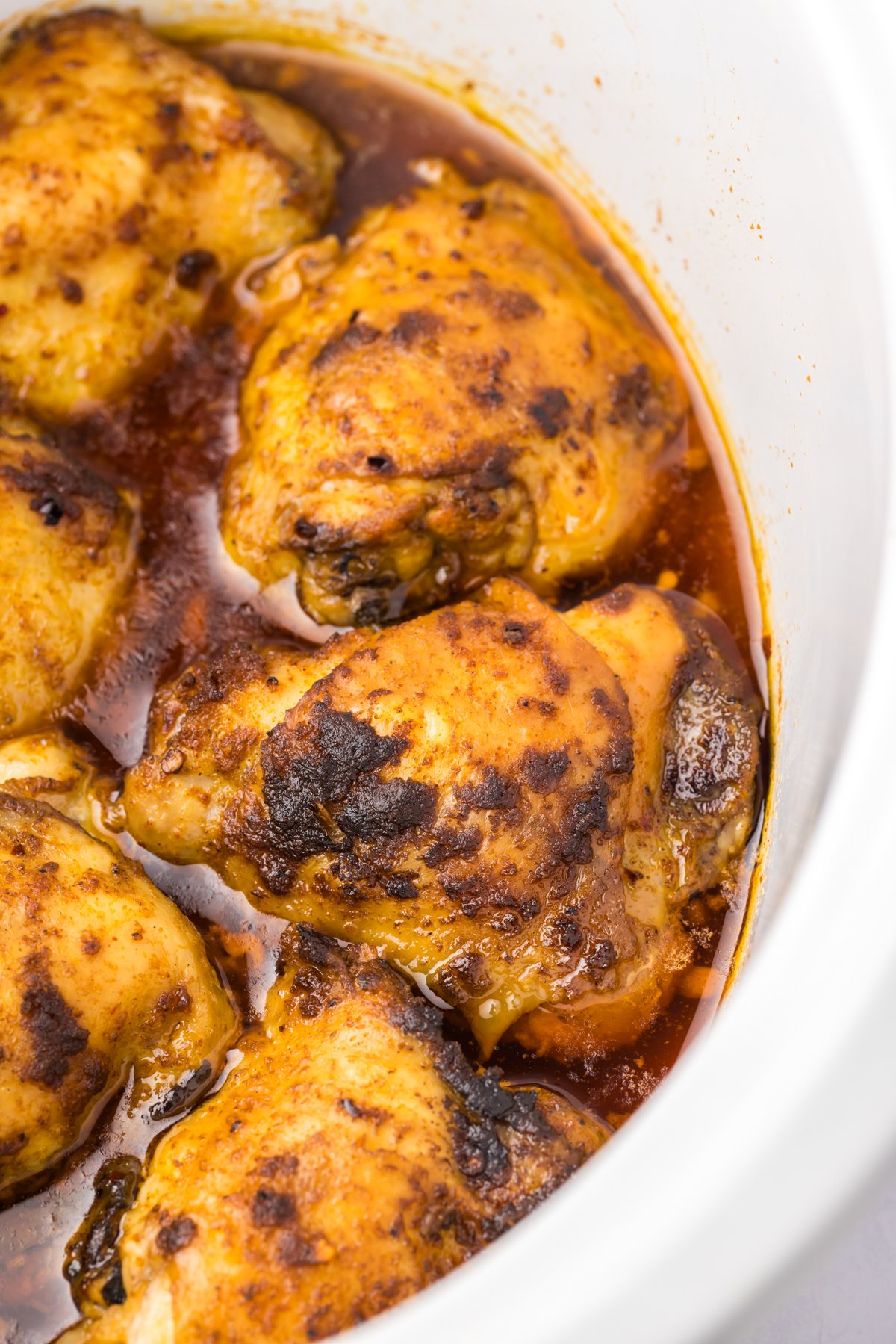 close-up shot of chicken thighs in a slow cooker.