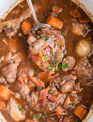 spoonful of crockpot coq au vin being held up.