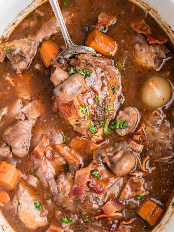spoonful of crockpot coq au vin being held up.