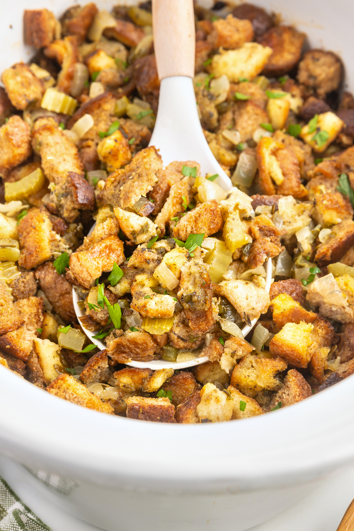 cooked stuffing in a white slow cooker.