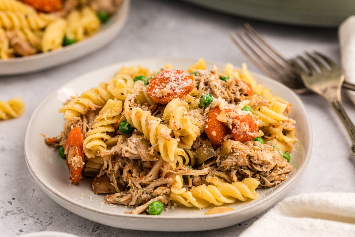 serving of slow cooker garlic butter chicken and pasta on a white plate.