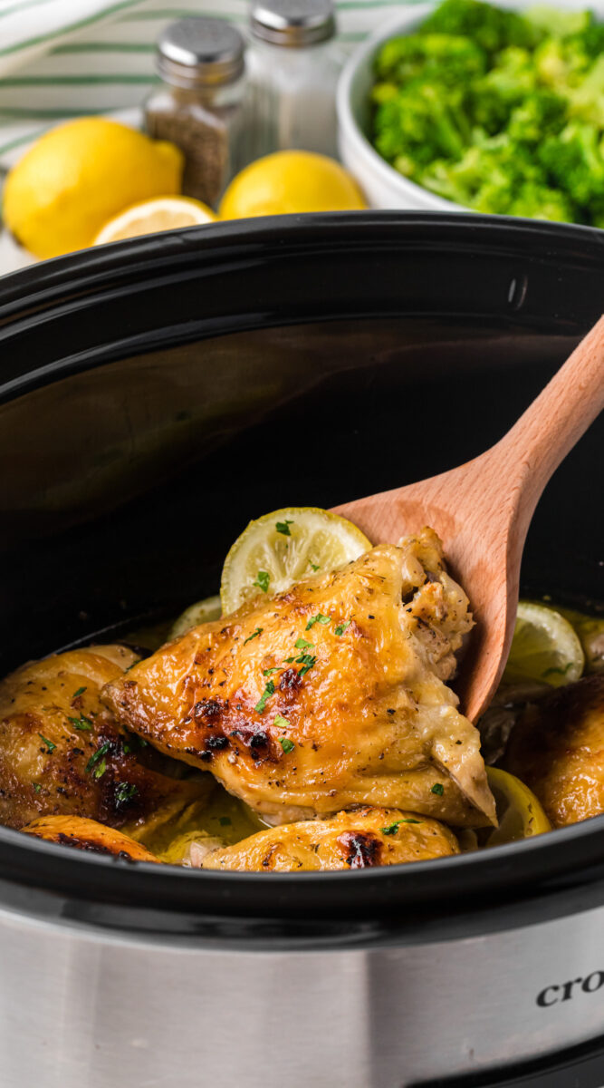 long image of lemon pepper chicken thighs in a slow cooker.