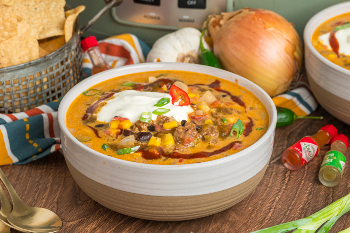 Bowl of nacho soup with sour cream on top.