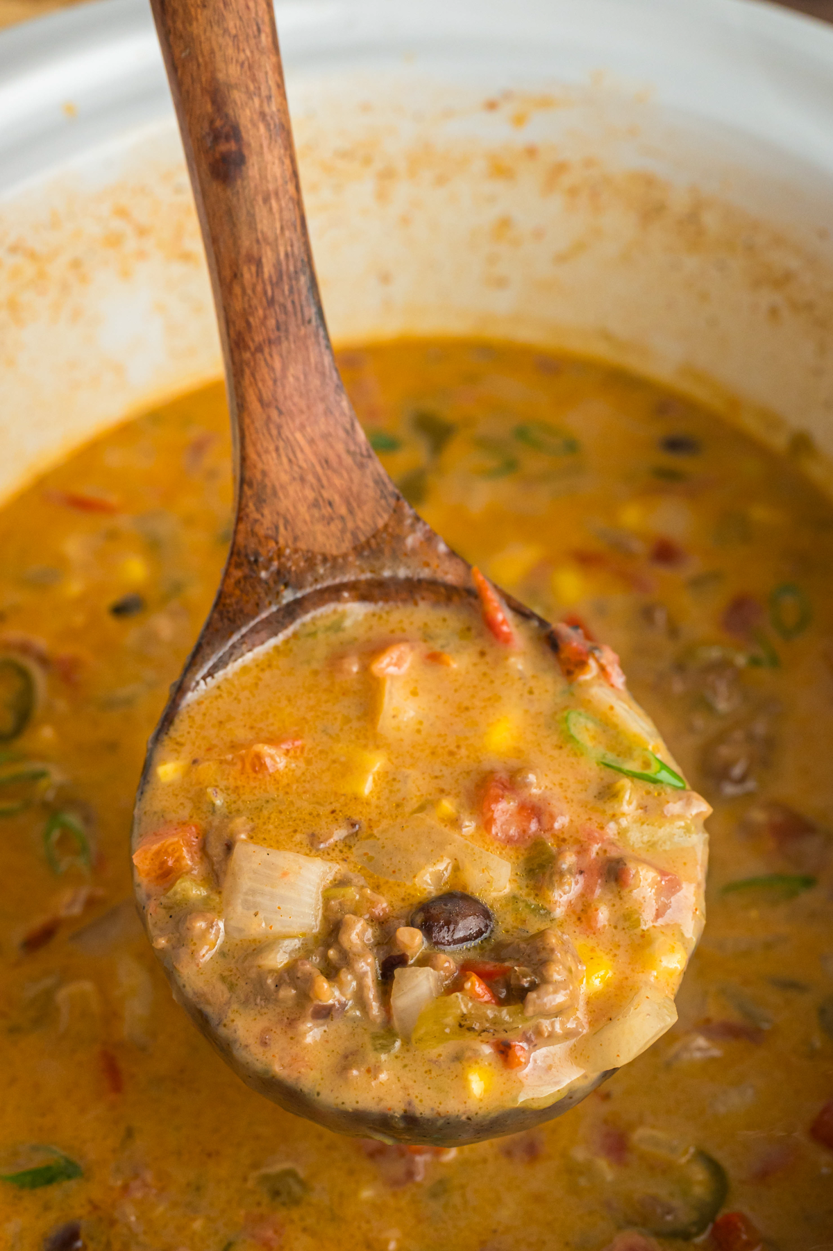 Nacho soup in a ladle.