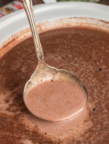 Nutella hot chocolate in a slow cooker and in a metal ladle.